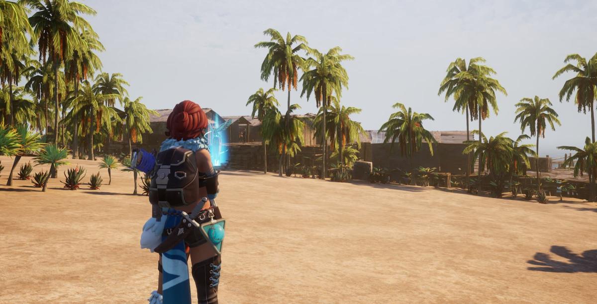 A female character from Palworld stands in front of a village of wooden houses against a beige beach.
